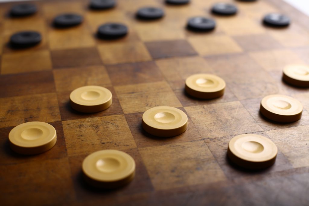 Checker pieces arranged on a board. All the pieces always occupy only black squares so can only be next to each other diagonally